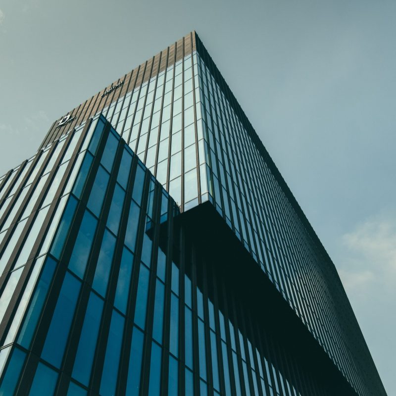 low angle shot of a building in a glass facade under the beautiful cloudy sky